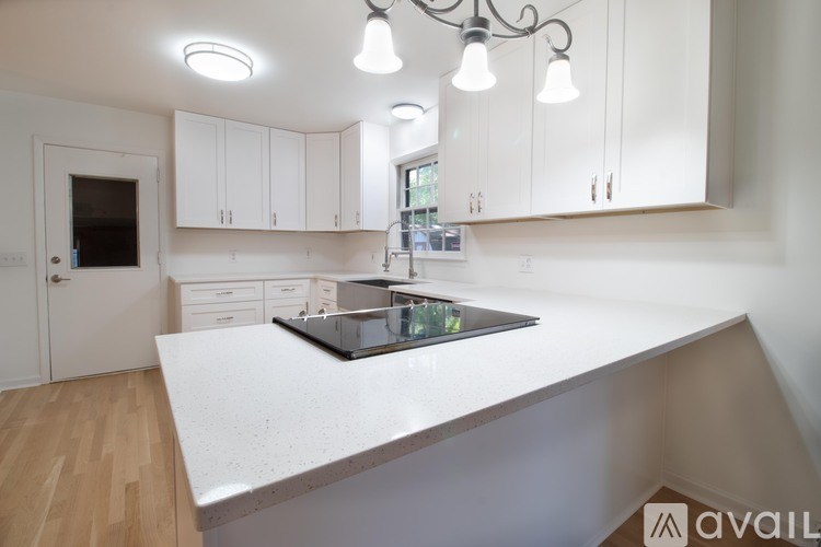 A kitchen with white cabinets and a large island.