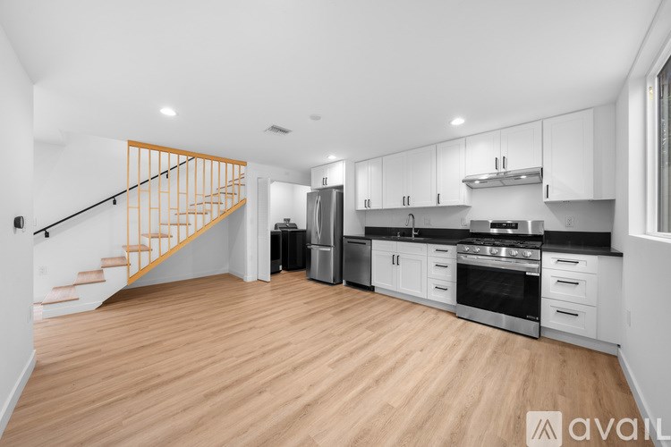 A kitchen with wooden floors and white walls.