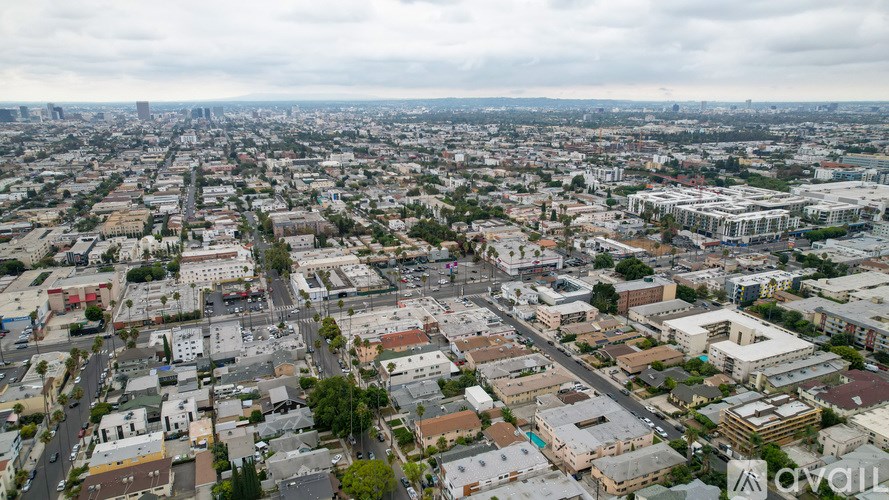 A cityscape with buildings of various sizes and a cloudy sky.