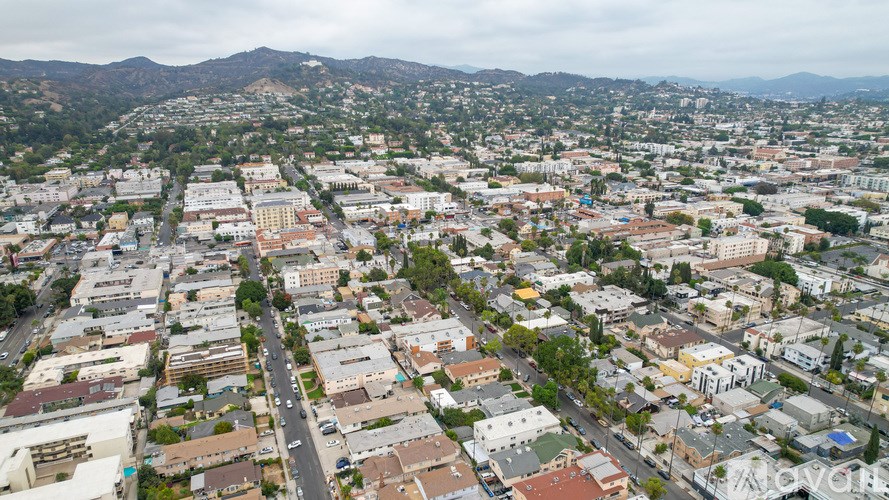 A cityscape with buildings and roads under a cloudy sky.