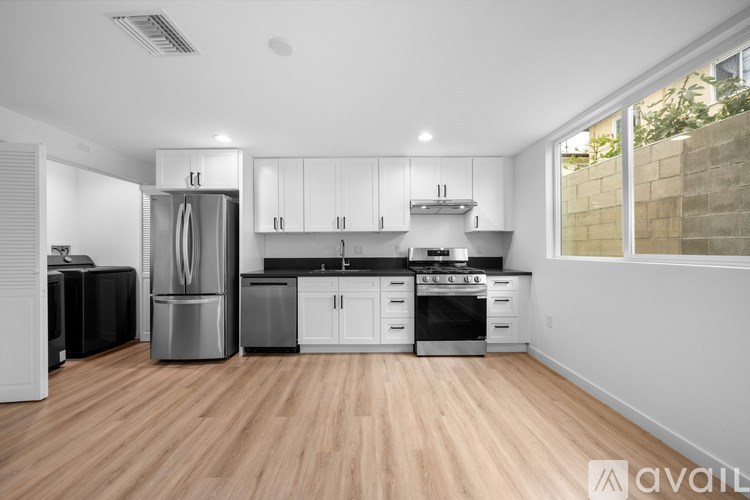 A kitchen with wooden floors and stainless steel appliances.