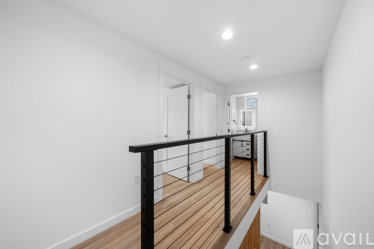 A balcony with a black railing and wooden floor.