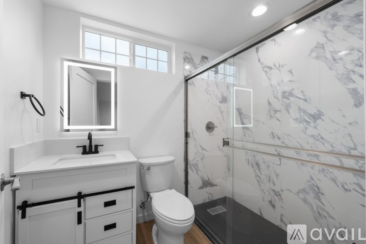 A bathroom with a marble wall and a white sink.