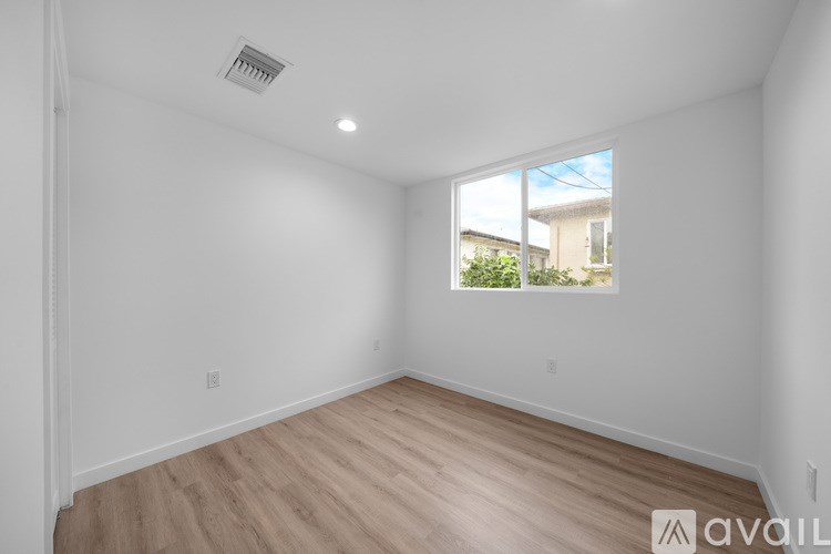 A room with a window and wooden flooring is available for rent.