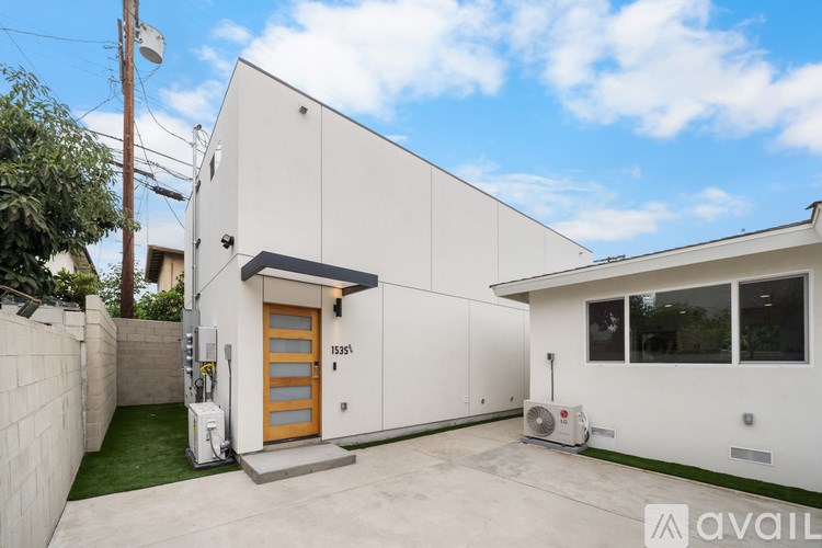 A modern house with a white exterior and a wooden door.