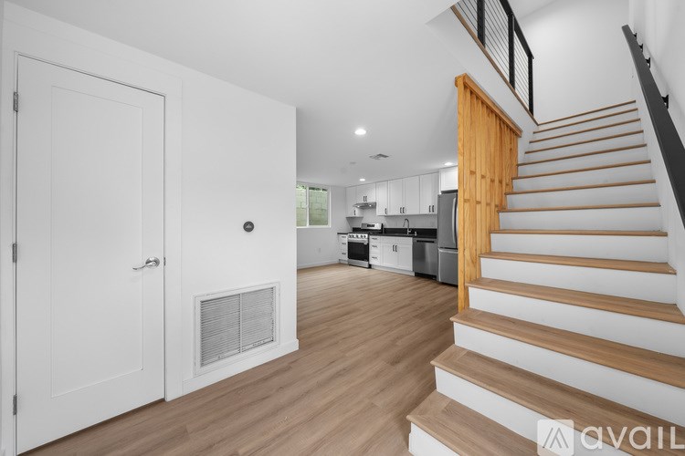 A modern kitchen with a staircase leading to the upper floor.