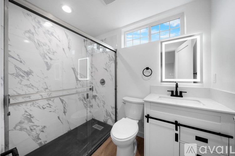 A bathroom with a marble shower and toilet area.