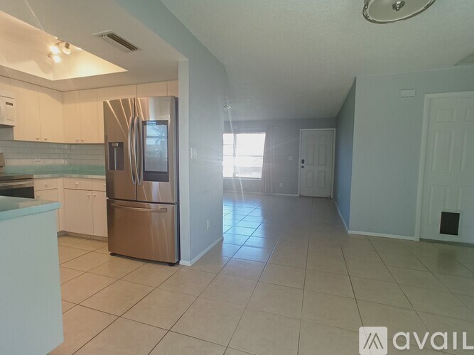 A room with a carpeted floor, a white wall, a brown door, and a white closet with a mirror.