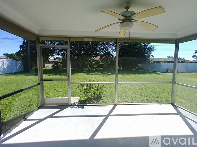 A patio with a ceiling fan and sliding glass doors.