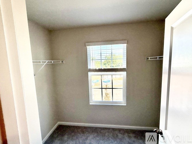 A small room with a window and two shelves.