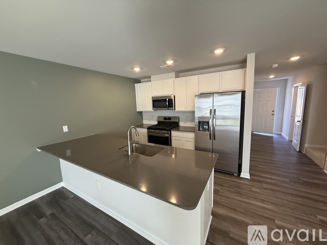 A modern kitchen with stainless steel appliances and a large island.