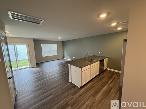A kitchen with white cabinets and a wooden floor.