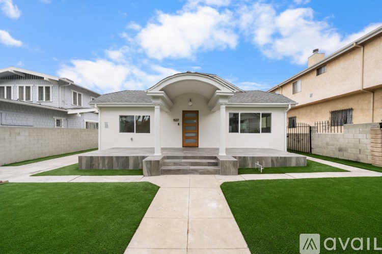 A modern house with a front yard and a clear sky.