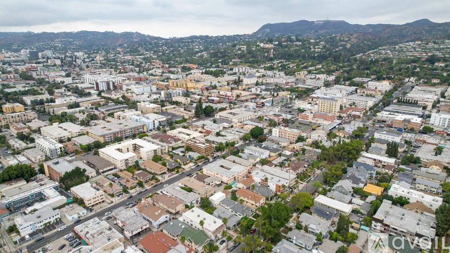 A cityscape with buildings of various sizes and a mountain range in the distance.