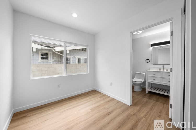 A bathroom with a toilet, sink, and mirror.