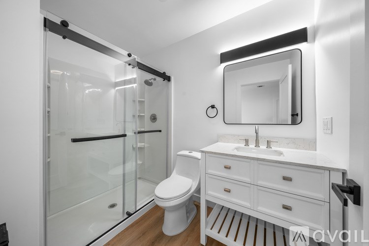 A white bathroom with a toilet, sink, and mirror.