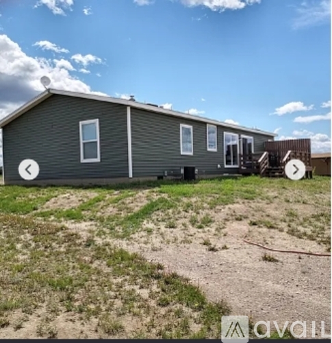 A grey house with a white door and windows is for sale.