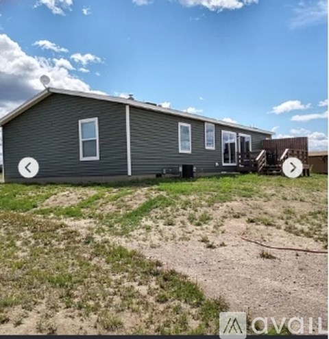 A grey house with a white door and windows is for sale.