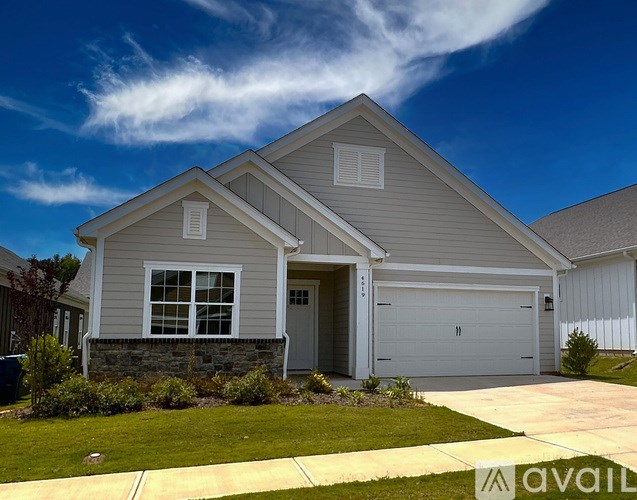 A two-story house with a garage and a driveway.