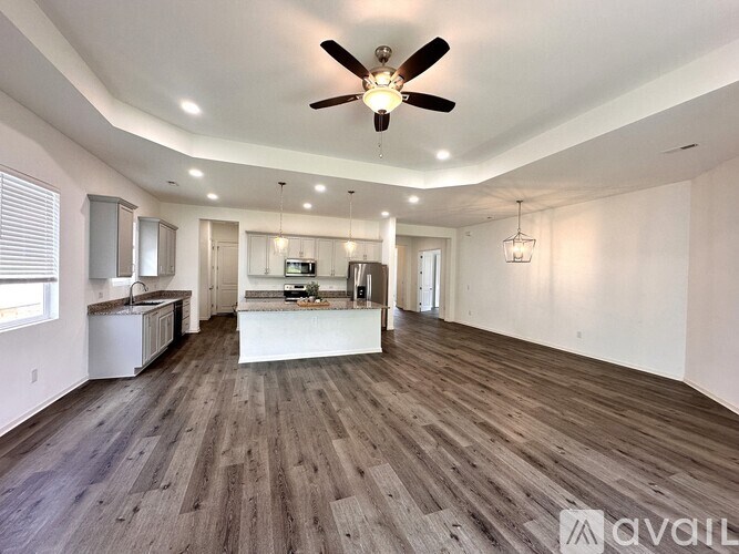 A spacious room with a ceiling fan and wooden flooring.