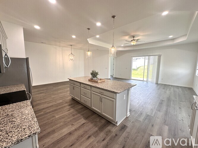 A kitchen with a granite countertop and wooden flooring.
