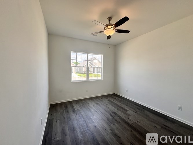 A room with a ceiling fan and a window.