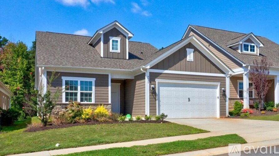 A house with a garage and a driveway in front.