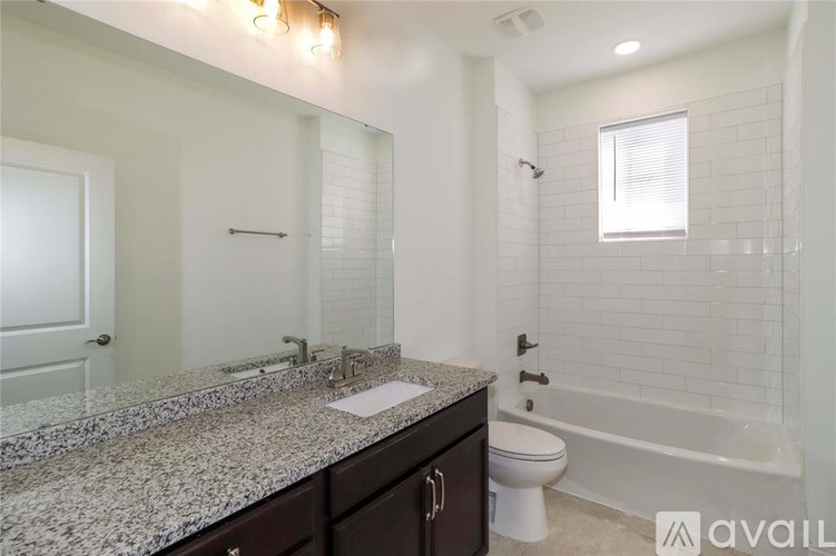A bathroom with granite countertops and a white toilet.