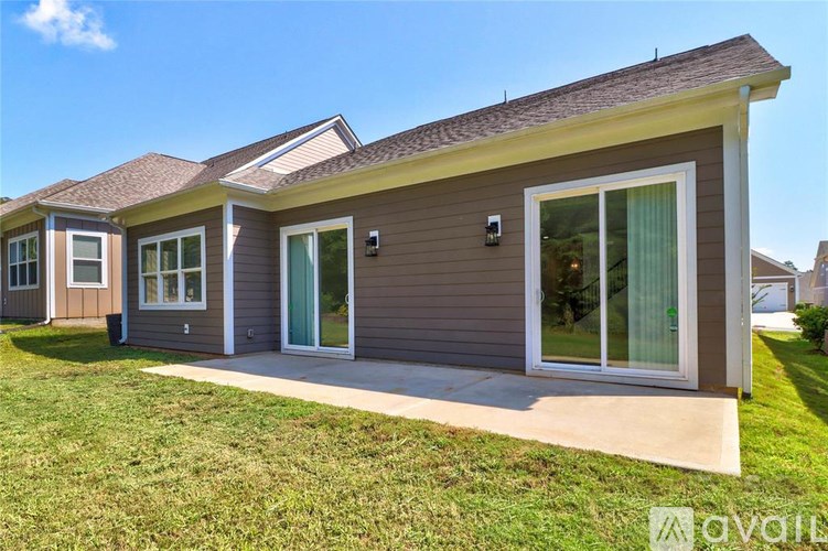 A house with a brown siding and a grey roof is available for rent.