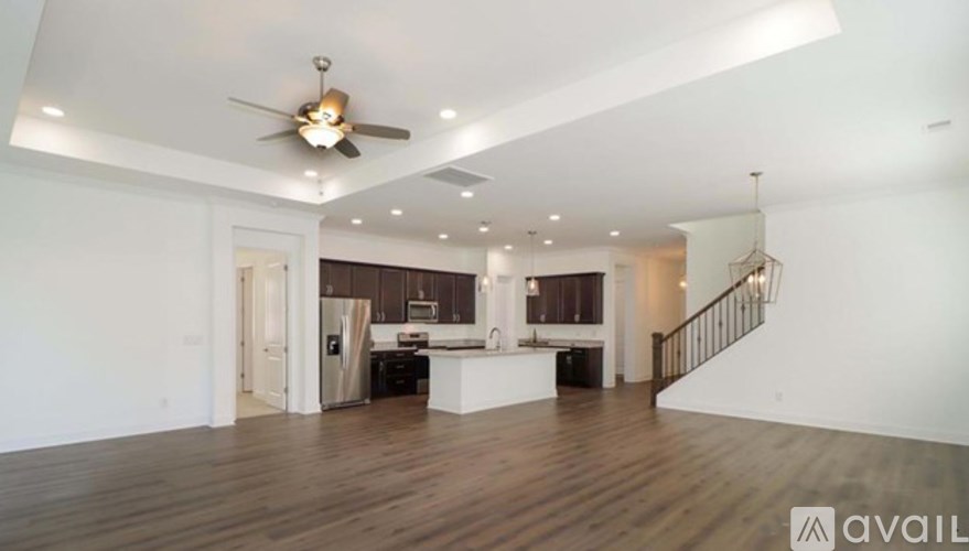 A spacious living room with a staircase leading to the upper floor.