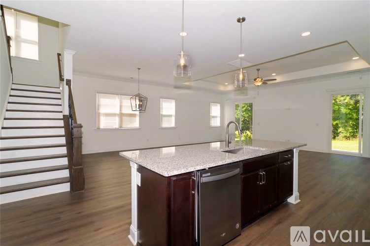 A kitchen with a maroon island and a staircase on the left.