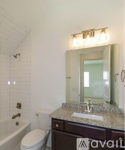 A bathroom with a white toilet, a sink, and a mirror.