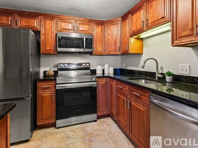 A kitchen with wooden cabinets and a black countertop.