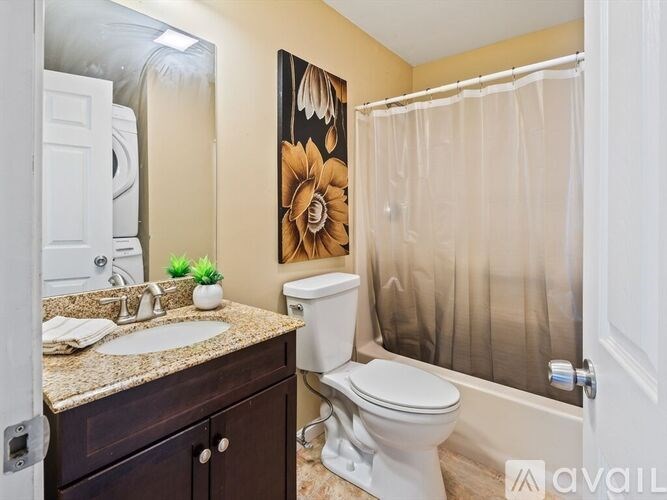 A bathroom with a toilet, sink, and shower curtain.