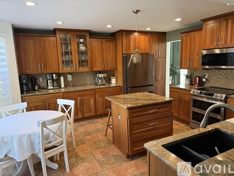 A kitchen with wooden cabinets and a granite countertop.