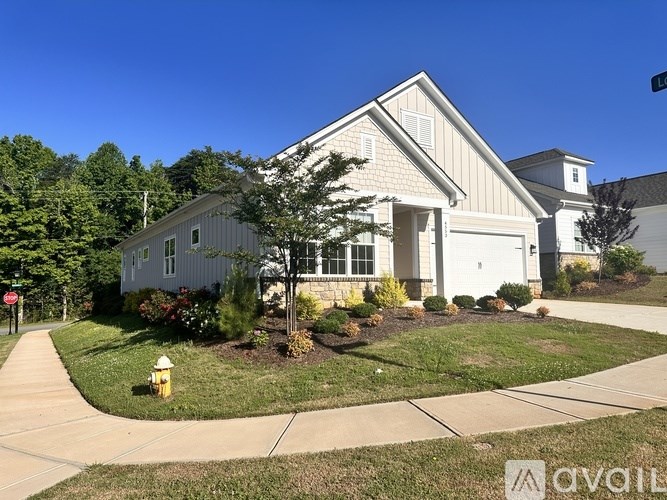 A house with a white garage door and a yellow fire hydrant in front of it.
