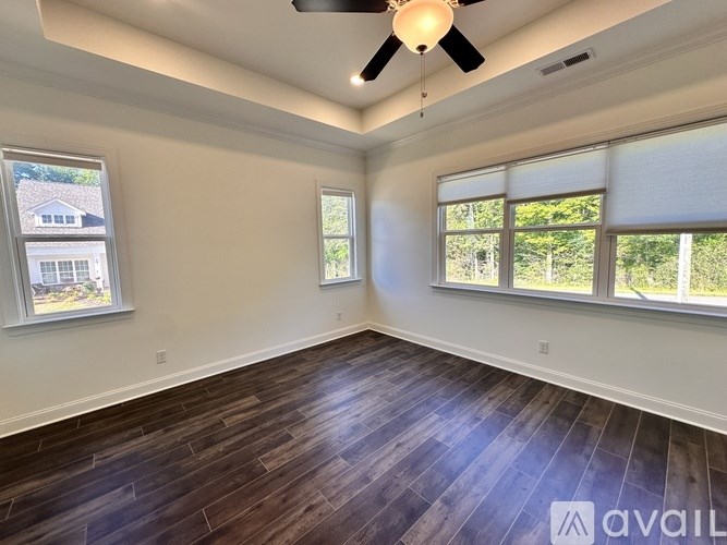 A room with wooden flooring and a ceiling fan.