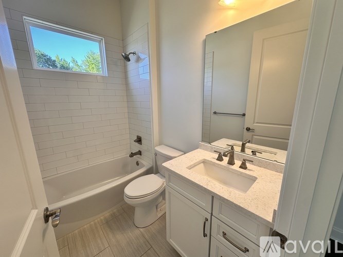 A bathroom with a toilet, sink, and a window.