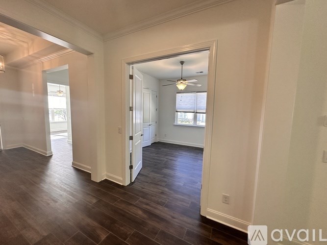 A room with a wooden floor and a ceiling fan.