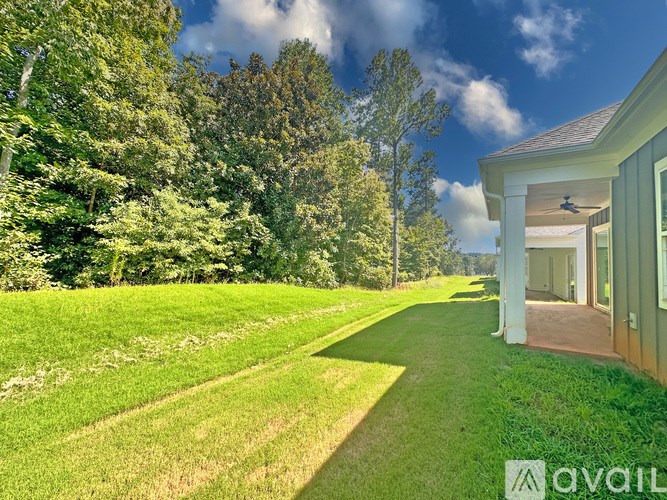 A house with a lawn and trees in the background.