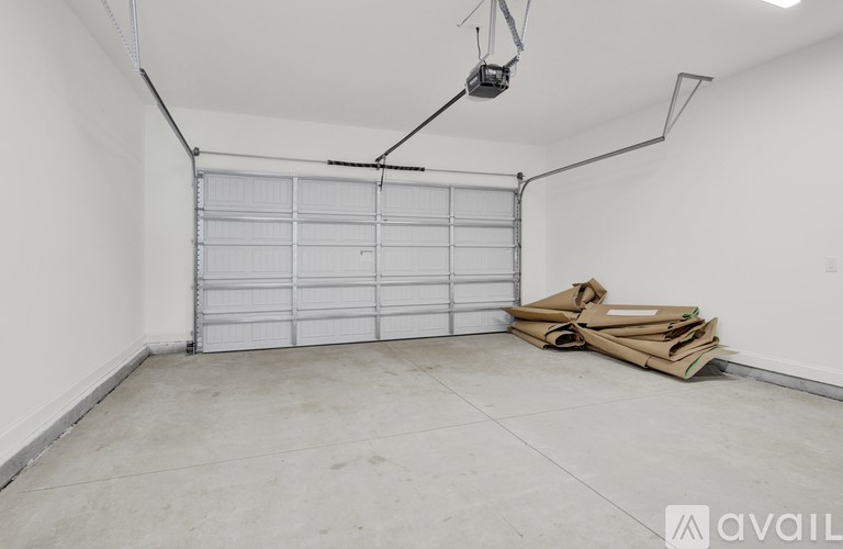 A garage with a closed white door and a cardboard box on the floor.