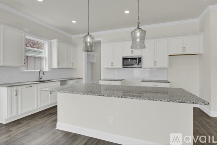 A kitchen with granite countertops and white cabinets.