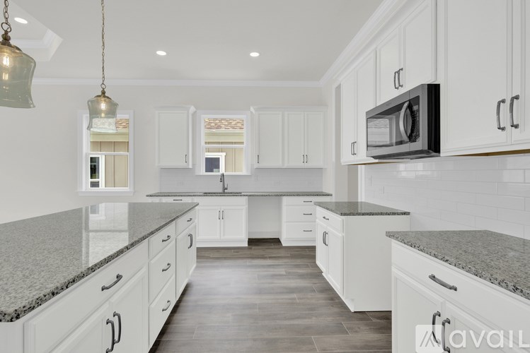 A kitchen with white cabinets and a granite countertop.