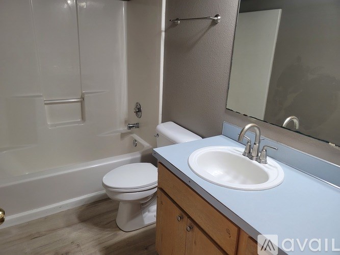 A bathroom with a toilet, sink, and mirror.
