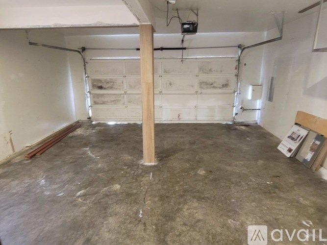 A room with a concrete floor and a white wall with a door and a window.