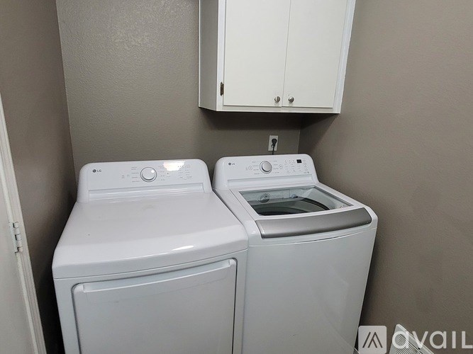 A white washing machine and dryer in a small laundry room.