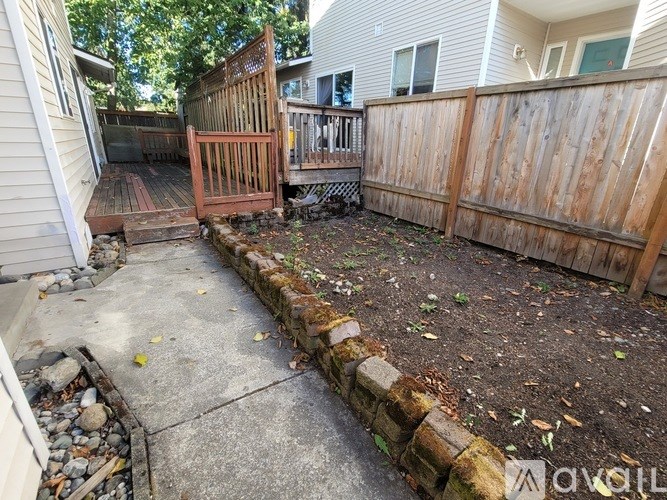 A backyard with a wooden fence and a small retaining wall.