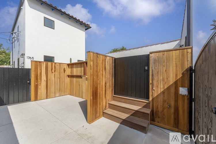 A modern house with a wooden fence and a black door.
