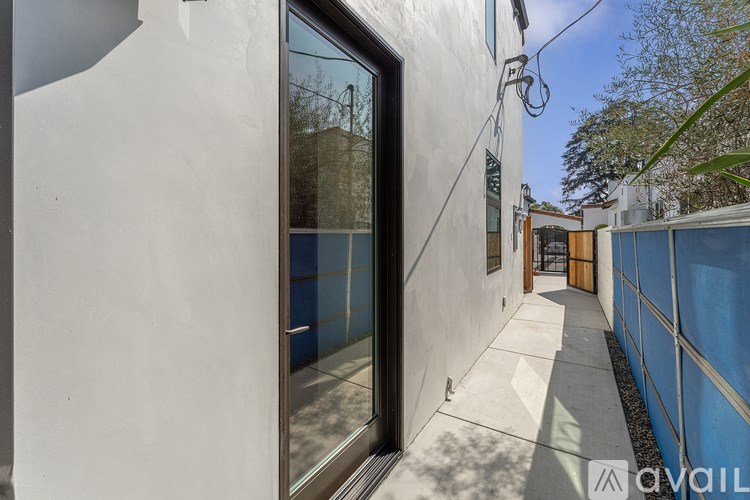 A white building with a glass door and a sign that says "available".