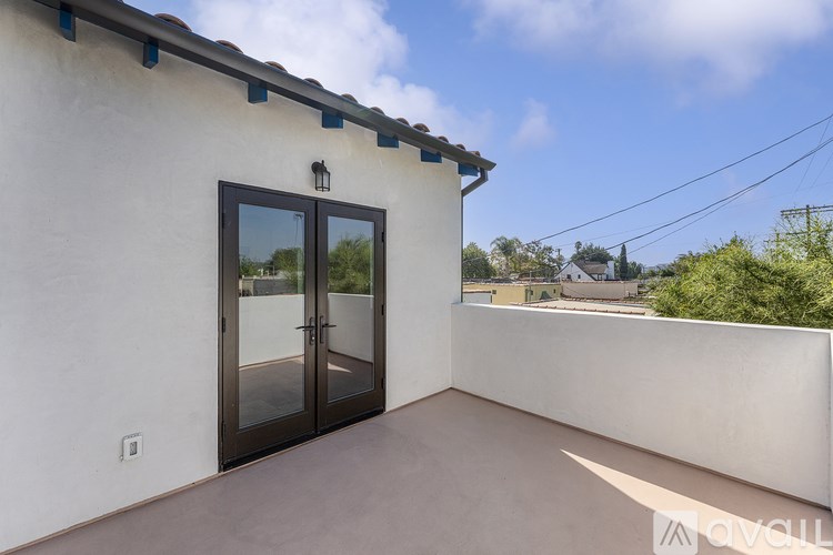 A balcony with a door and a wall.